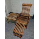 A folding teak garden lounger with foot rest together with matching coffee table