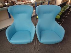 A pair of contemporary wingback armchairs on metal legs upholstered in a blue fabric