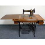 A 20th century Singer treadle sewing machine in oak table
