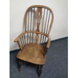 An antique elm Windsor high backed kitchen armchair