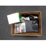 A box containing an X Box 360 with accessories and games