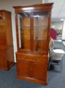 A Bradley Furniture reproduction yew wood glazed double door bookcase fitted cupboard and drawer
