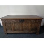 An early 19th century heavily carved oak blanket box