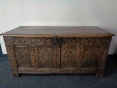 An early 19th century heavily carved oak blanket box