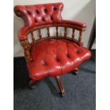 A red button leather captain's swivel desk chair