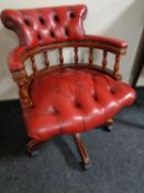 A red button leather captain's swivel desk chair