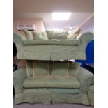 A two seater settee with matching two seater bed settee upholstered in a green and gold loose
