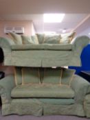A two seater settee with matching two seater bed settee upholstered in a green and gold loose