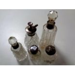 Five cut glass silver-topped and rimmed scent bottles