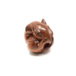 A carved hardwood netsuke - Rat scratching its nose