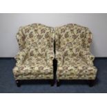 A pair of Parker Knoll wingback armchairs upholstered in a floral fabric