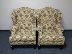 A pair of Parker Knoll wingback armchairs upholstered in a floral fabric