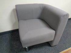 A contemporary corner chair upholstered in a grey fabric