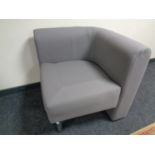 A contemporary corner chair upholstered in a grey fabric