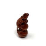 A carved hardwood netsuke - Rat climbing a spike