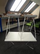 A pair of orange box bar stools on metal legs together with a coffee table on metal legs