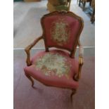A carved beech framed French salon armchair upholstered in a tapestry fabric (damaged)