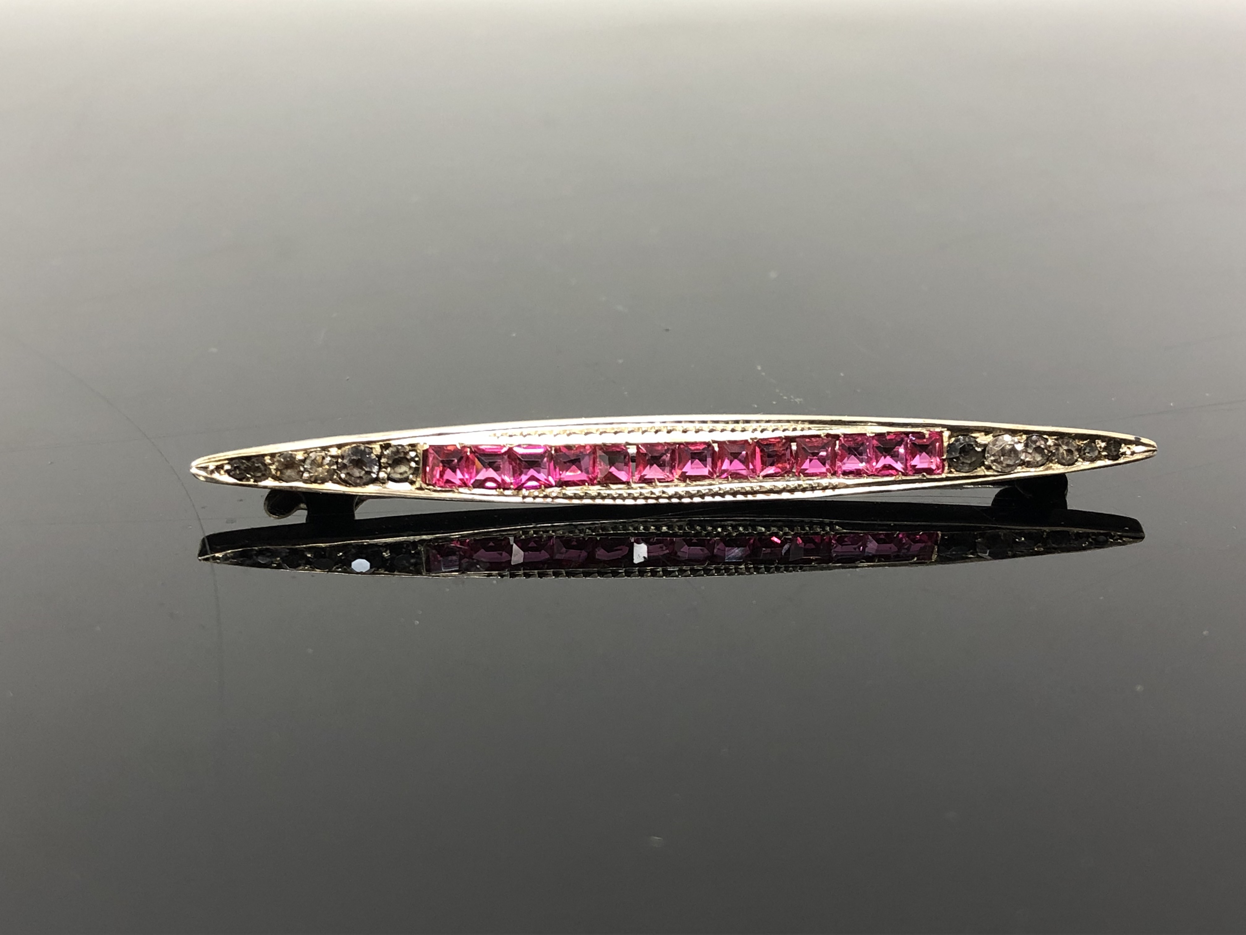 A vintage bar brooch set with pink stones