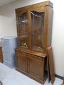 An Edwardian oak bookcase fitted double door cupboard and two drawers beneath