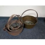 Three graduated cast iron cooking pots together with a brass cast iron handled jam pan