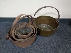 Three graduated cast iron cooking pots together with a brass cast iron handled jam pan