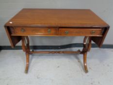 A Regency style inlaid mahogany sofa table fitted two drawers