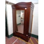 An antique mahogany mirror door wardrobe