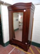 An antique mahogany mirror door wardrobe