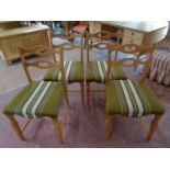 A set of four blonde oak dining chairs upholstered in a green striped fabric