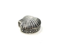 A small silver shell shaped pill box