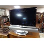 A Bang & Olufsen Beovision 7 TV on stand with remote