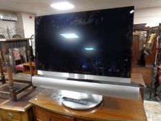 A Bang & Olufsen Beovision 7 TV on stand with remote