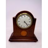 An Edwardian inlaid mahogany mantel clock with enamel dial on raised brass feet