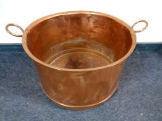 An antique copper twin handled pot,