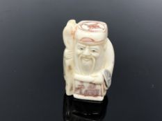 A carved hardwood netsuke - Village elder with staff and scroll