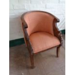 A reproduction carved mahogany tub elbow chair upholstered in a pink fabric