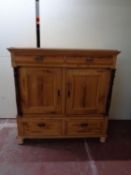 A 19th century pine double door linen cupboard fitted four drawers