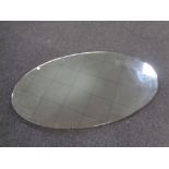 A large oval frameless mirror