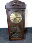 An Edwardian oak cased eight day wall clock with brass dial