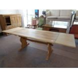 A blonde oak refectory dining table with two extension leaves