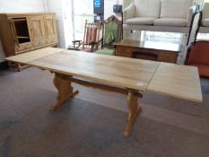 A blonde oak refectory dining table with two extension leaves