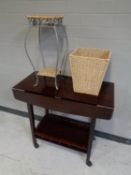 A contemporary two tier flap sided tea trolley together with a wicker and metal two tier plant