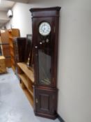 A mahogany corner cabinet fitted with a clock,