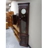 A mahogany corner cabinet fitted with a clock,