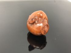 A carved hardwood netsuke - Rats playing in a pot