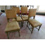 A set of four antique painted dining chairs upholstered in a gold fabric