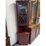 A corner display cabinet in a mahogany finish