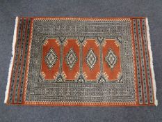 A fringed woolen Persian rug of geometric design