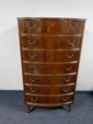 A mid 20th century walnut bow fronted seven drawer chest