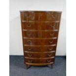 A mid 20th century walnut bow fronted seven drawer chest